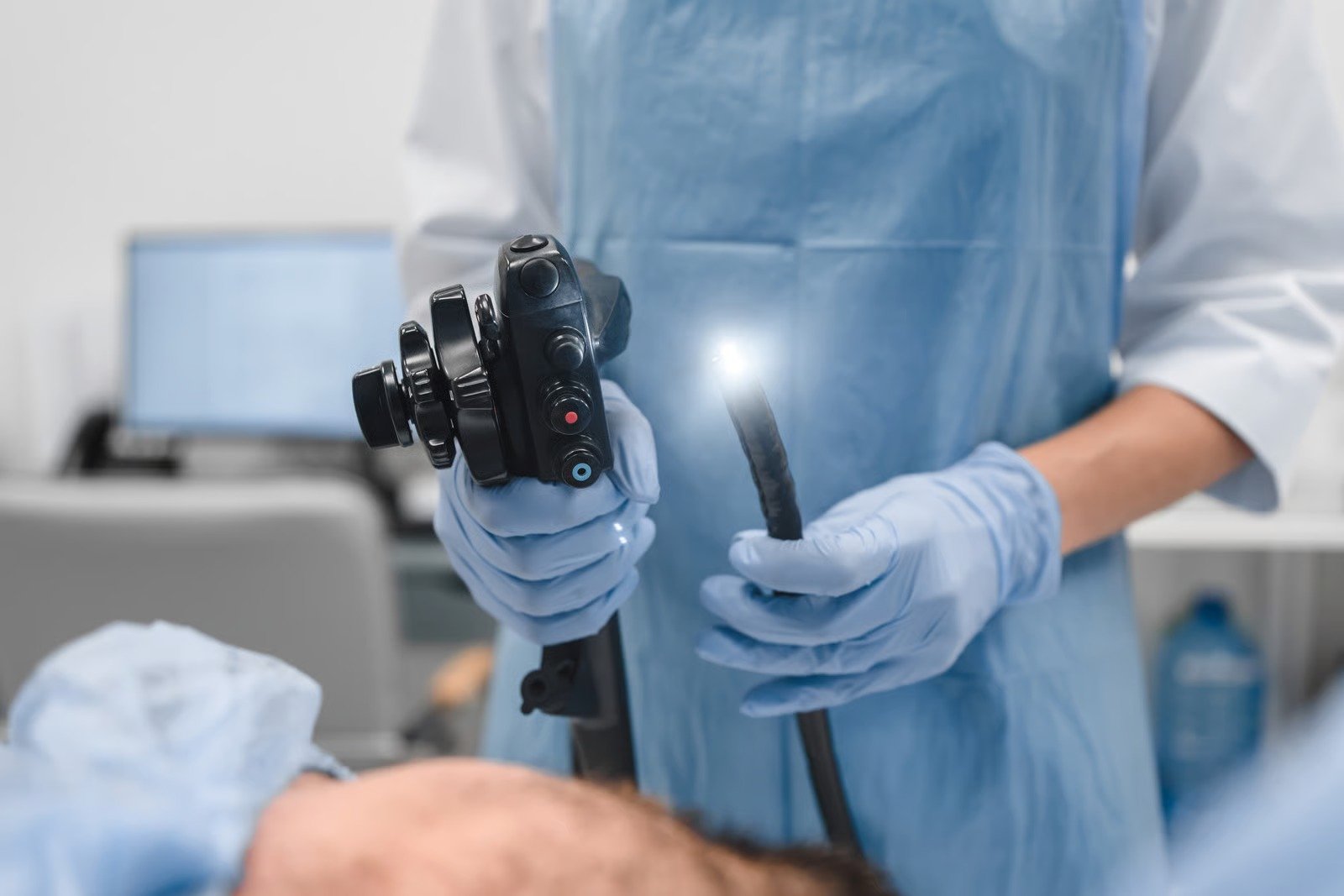 Endoscopist holding a lit flexible endoscope beside a patient before an upper GI endoscopy at Kapadia Hospital, Mumbai