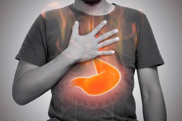 Man holding his upper abdomen with the stomach highlighted, showing epigastric hernia pain - Kapadia Hospital, Mumbai