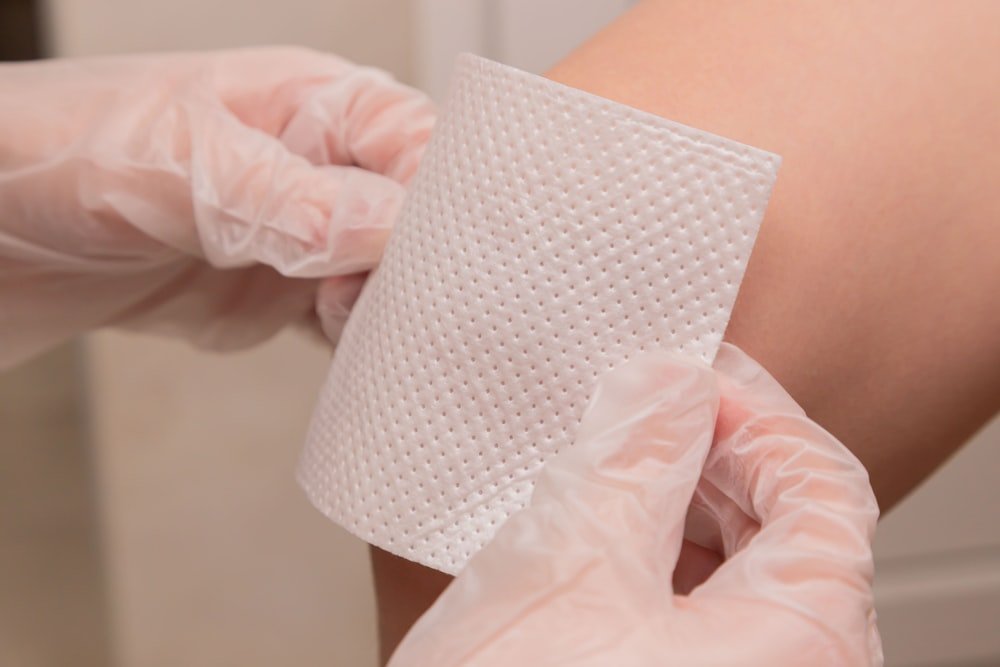Gloved clinician applying a sterile wound dressing at Kapadia Hospital, Mumbai