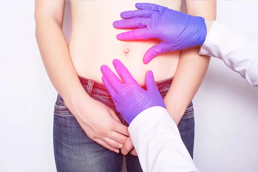 Doctor examining a patient's abdomen around the navel to check for an umbilical hernia - Kapadia Hospital, Mumbai